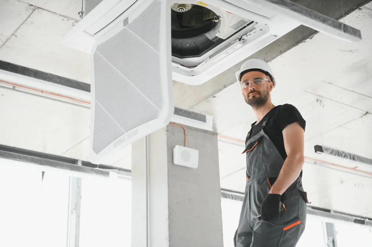 Happy Male Technician Repairing Air Conditioner Large At Η Εταιρεία